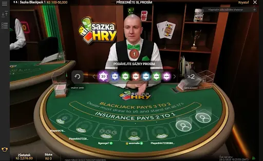 Krupiér Hry Blackjack čekající na sázky hráčů v online kasinu. Krupiér u stolu Hry Blackjack připravený přijímat sázky od hráčů.